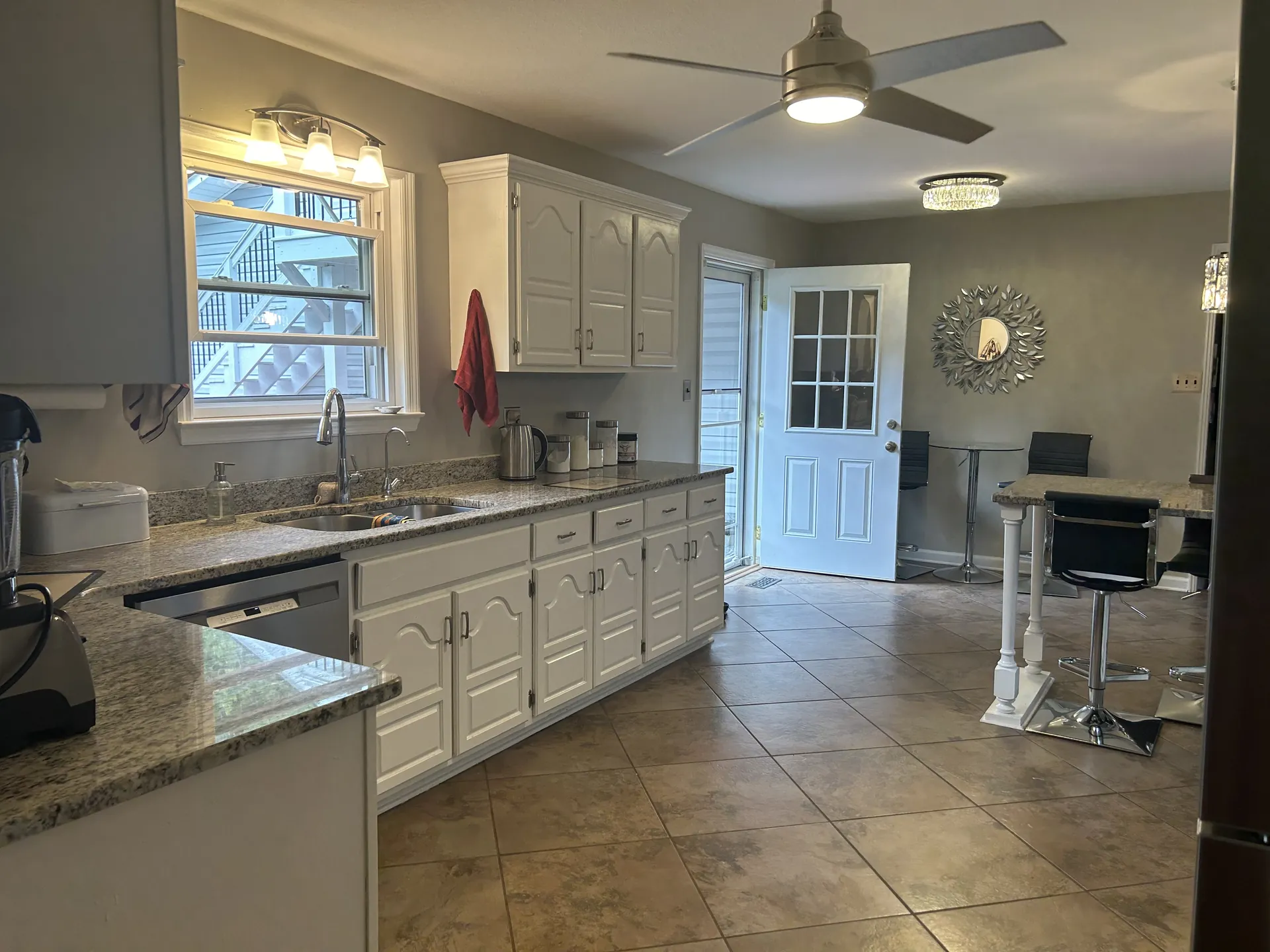 Updated kitchen with white cabinetry and tile flooring